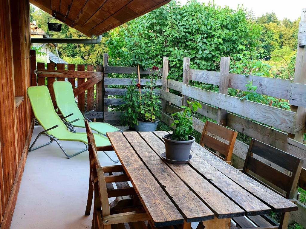 una mesa de madera y sillas en un patio en Les Vergers d'Epona "Fremifontaine VOSGES" en Frémifontaine