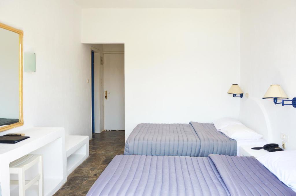 a hotel room with two beds and a mirror at Patmos Paradise Hotel in Kámbos