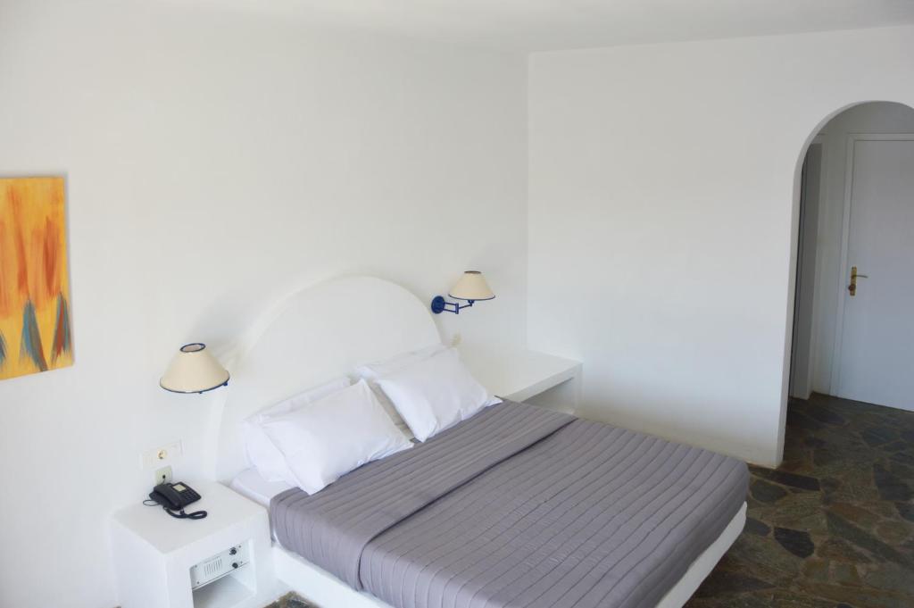 a bedroom with a bed and two night stands at Patmos Paradise Hotel in Kámbos