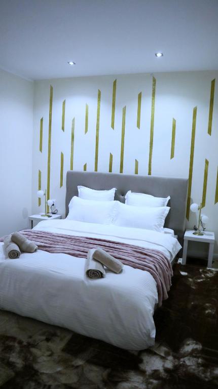 a bedroom with a large bed with white pillows at Apartament Royal in Dej