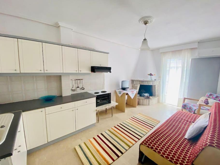 a kitchen with white cabinets and a couch in a room at Queen's apartment in Olympic Beach