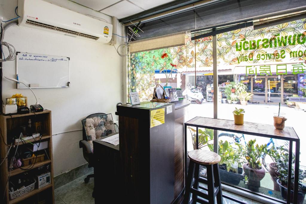 een restaurant met een bar voor een raam bij OYO 75440 Nara Hostel in Bangkok