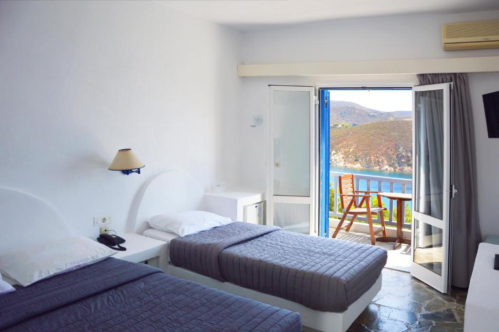 a hotel room with two beds and a balcony at Patmos Paradise Hotel in Kámbos