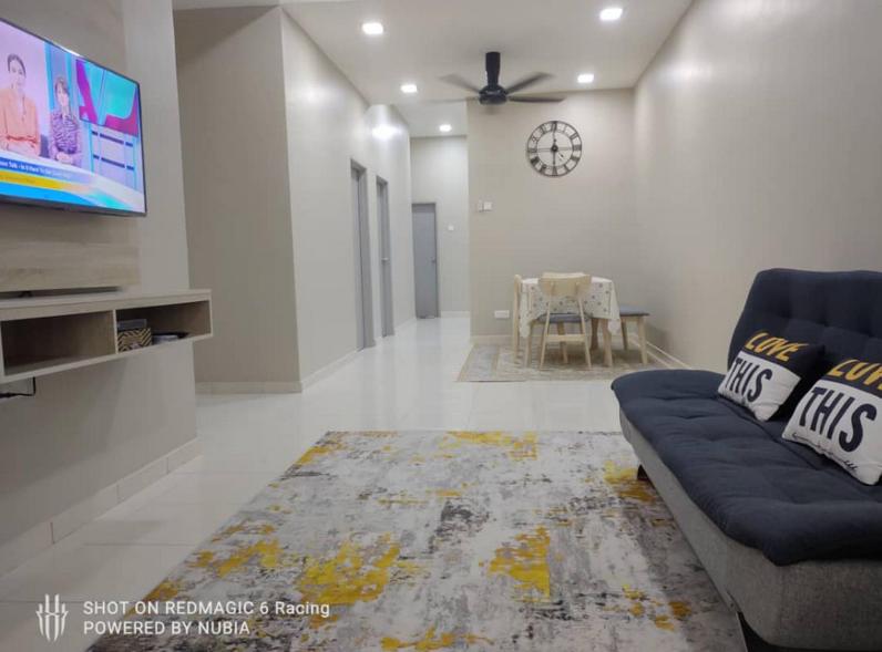 uma sala de estar com um sofá e uma televisão de ecrã plano em Aisyah Homestay Kuantan - Jaya Gading em Kampong Seri Permatang Gading
