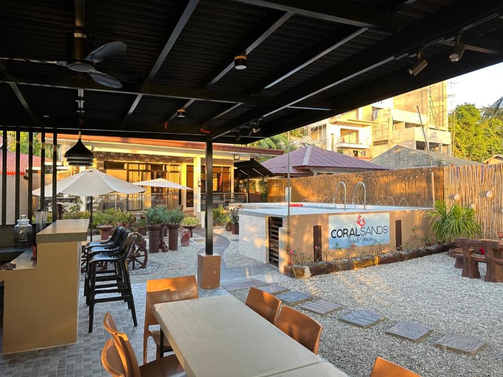 un patio esterno con tavoli, sedie e camino di Beach getaway Studio Villa in Lobo a Lobo