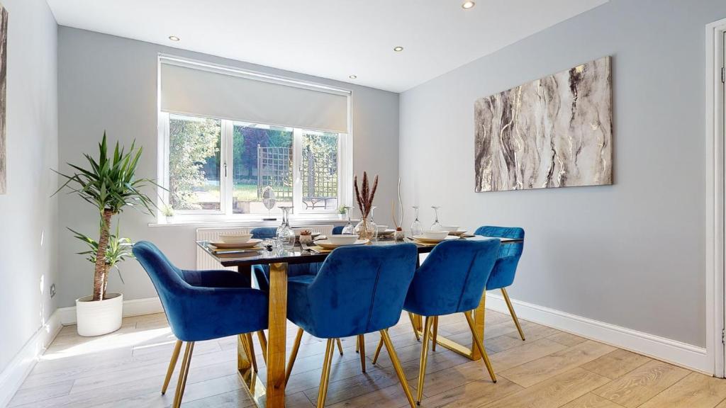 a dining room with a table and blue chairs at Stunning 5 Bed Detached Home Nottingham in Nottingham