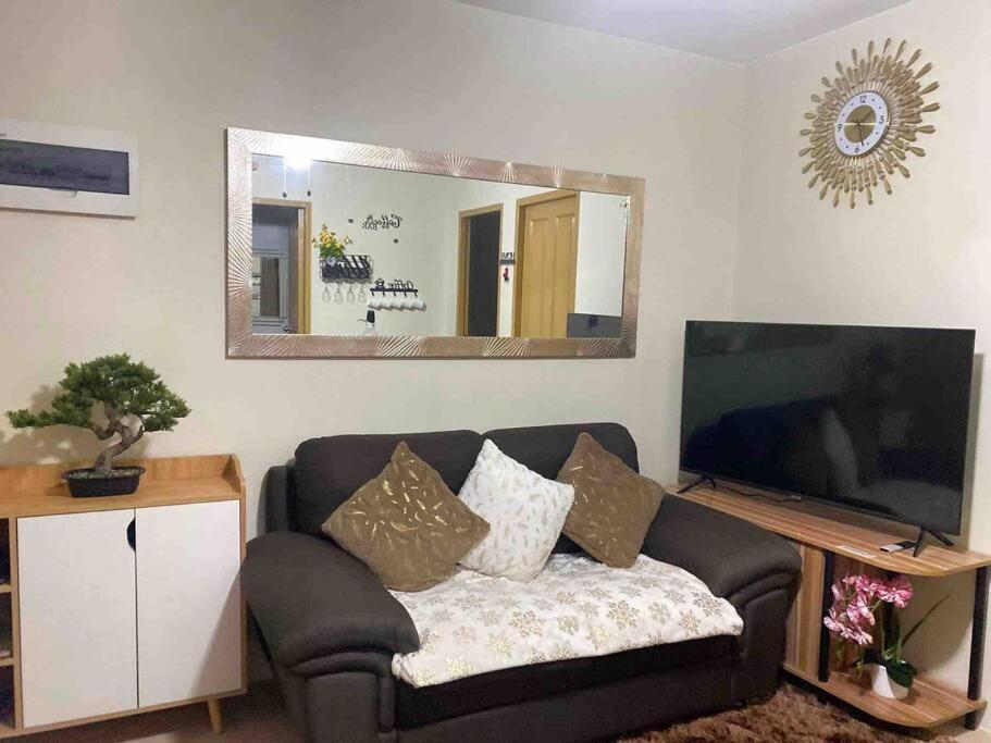 ドゥマゲテにあるJETT Condo Rental at Marina Spatialのリビングルーム(ソファ、大きな鏡付)