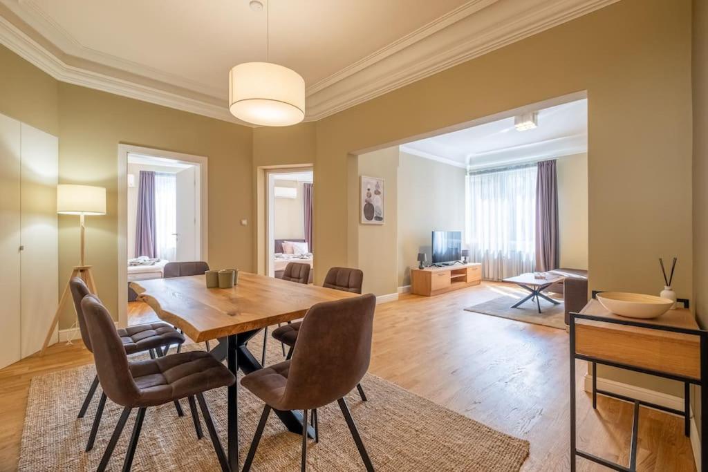 a dining room with a wooden table and chairs at Stunning Luxury 3 Bedroom Apt in the Heart of Town in Sofia