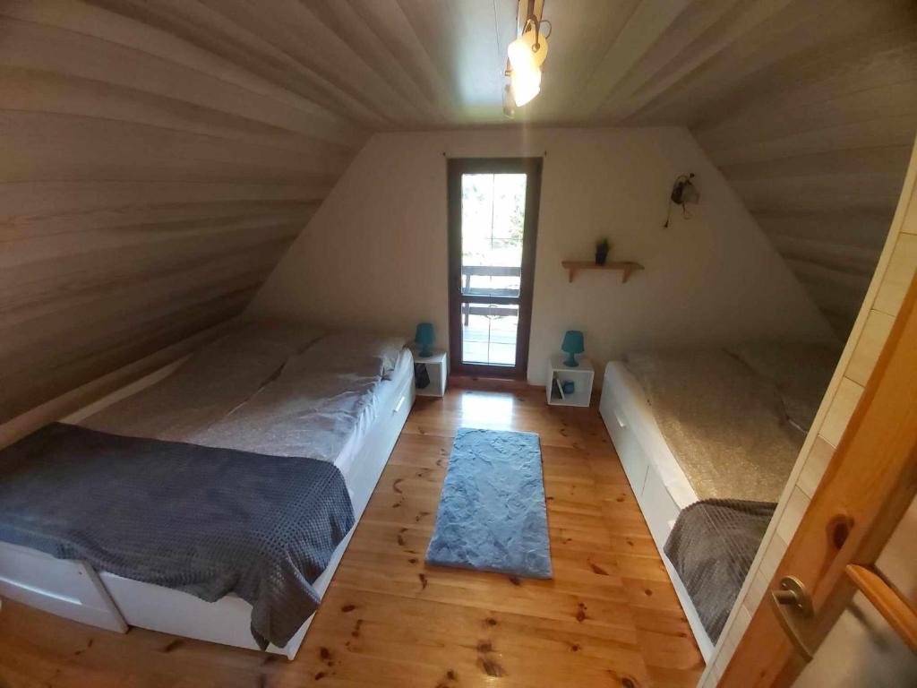 a room with two beds in a attic at Uroczy domek letniskowy z kominkiem 100m2 in Bogaczewo