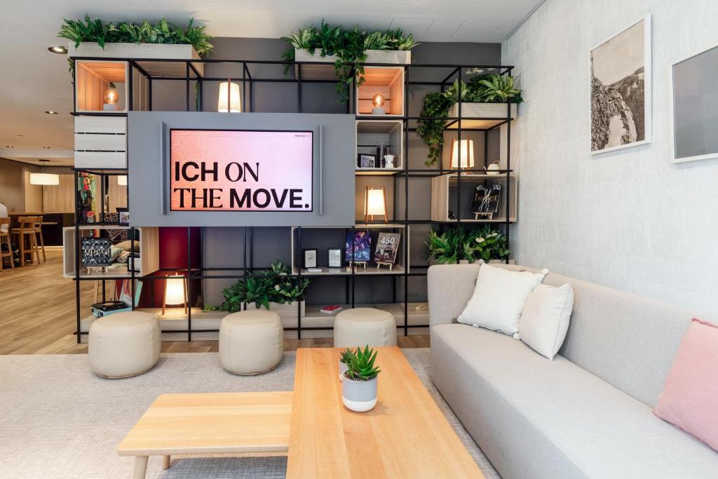 a living room with a couch and a sign catch on the movie at IntercityHotel Wien in Vienna