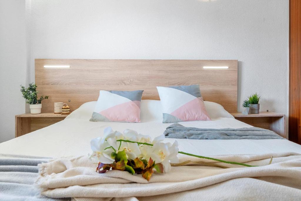 ラ・ピネーダにあるAlea Rentals - Albenizのベッドルーム1室(白い花のベッド1台付)