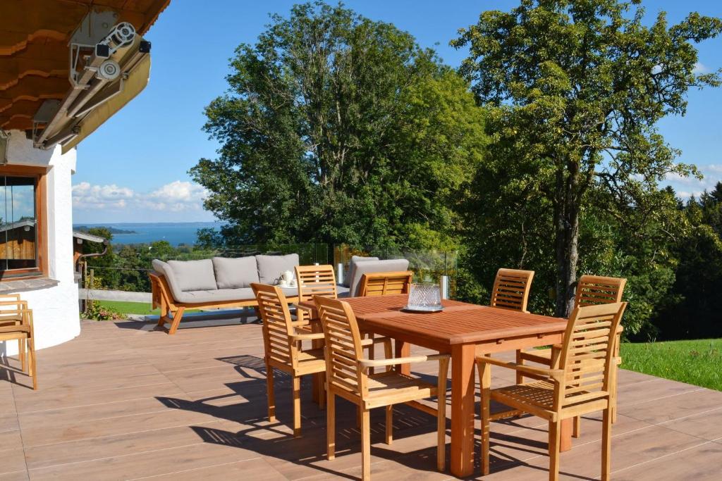 einen Holztisch und Stühle auf einer Terrasse in der Unterkunft Landsitz SeeBlick in Bernau am Chiemsee