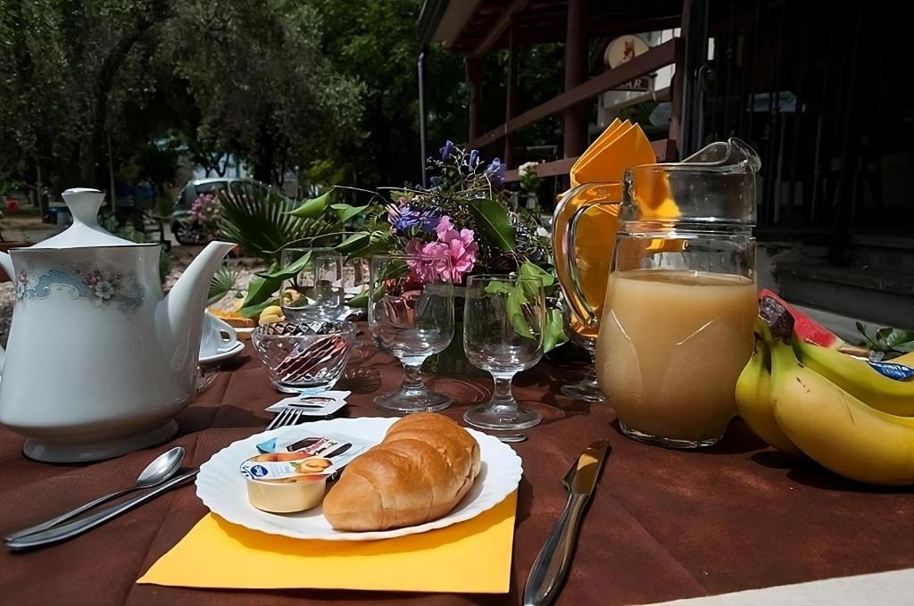 a table with a plate of bread and glasses of juice at Camping Almoetia in Calatabiano