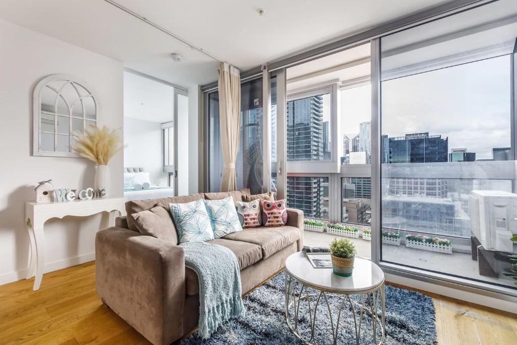 - un salon avec un canapé et une grande fenêtre dans l'établissement 'Rose Lane Retreat' Discover Melbourne City Charm, à Melbourne