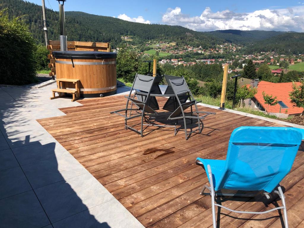 een terras met 2 stoelen, een grill en een hot tub bij Appartement du parc in Xonrupt-Longemer