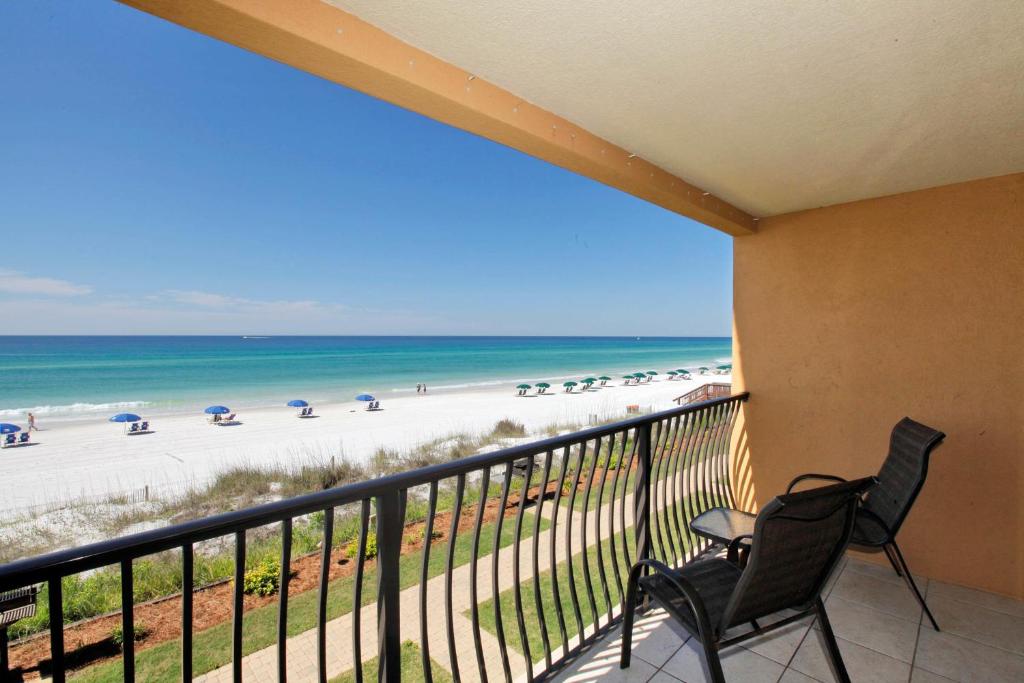 a balcony with two chairs and a view of the beach at Coral Reef Club by Panhandle Getaways in Destin