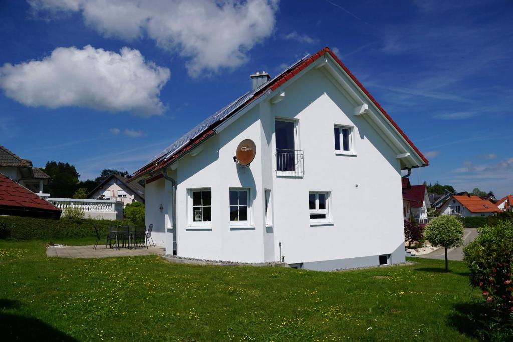 Ferienhaus Heck في Obernheim: بيت ابيض بسقف احمر