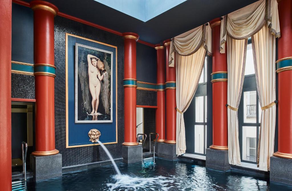 uma piscina num quarto com colunas vermelhas em InterContinental Bordeaux Le Grand Hotel, an IHG Hotel em Bordeaux