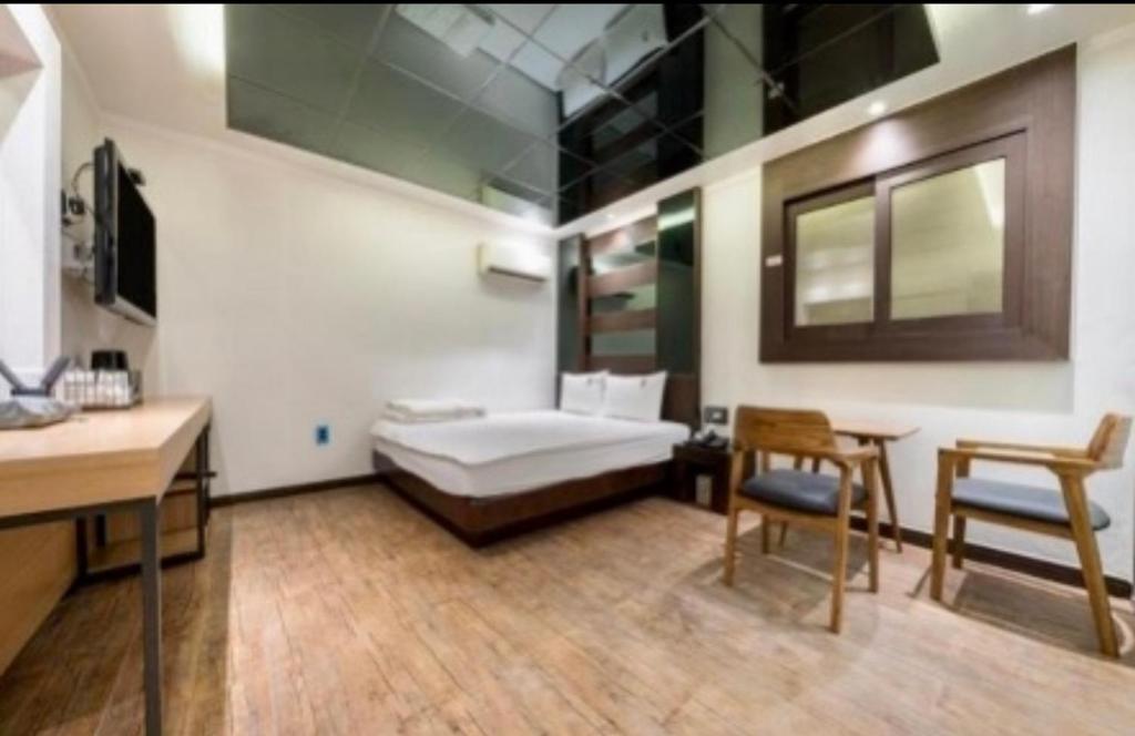 Zimmer mit einem Bett, einem Tisch und Stühlen in der Unterkunft Hotel Lien in Busan