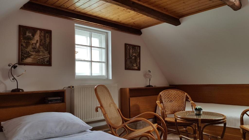 um quarto com uma cama, cadeiras e uma mesa em Modrá růže Třeboň em Třeboň