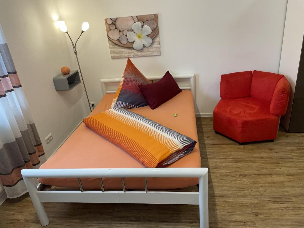 Una cama con almohadas y una silla en una habitación. en Festl Apartments - Nähe Messe München, Therme Erding, en Forstern