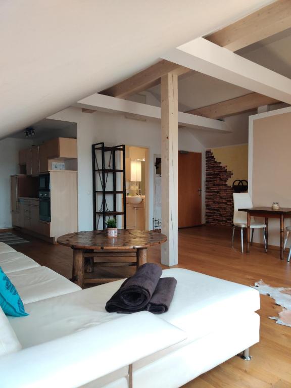 a living room with two white beds and a table at Festl Apartments in Forstern