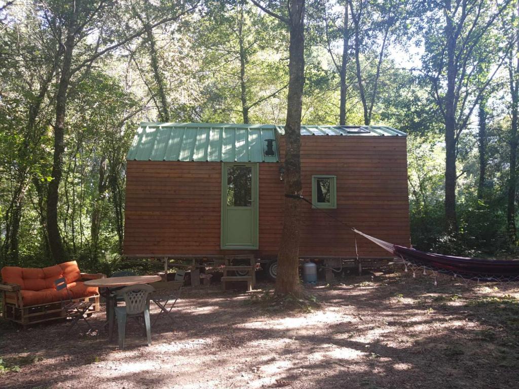 eine Hütte im Wald mit einem Tisch und einem Baum in der Unterkunft Tiny house in Miélan