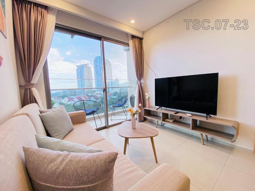 uma sala de estar com um sofá e uma televisão em The Sóng Apartment - Homestay Vũng Tàu 1992 em Vung Tau
