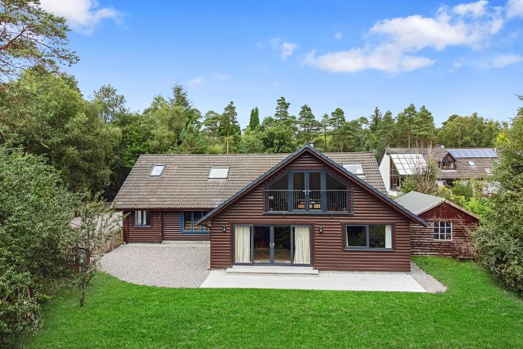 a wooden house with a green yard at Finest Retreats - The Logs in Fort William