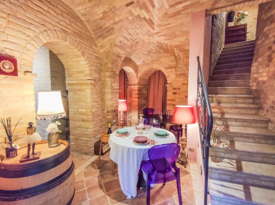 une salle de dégustation de vin avec une table et un escalier dans l'établissement La Scarpetta Magica: un incantevole soggiorno a 5 stelle!, à Offida