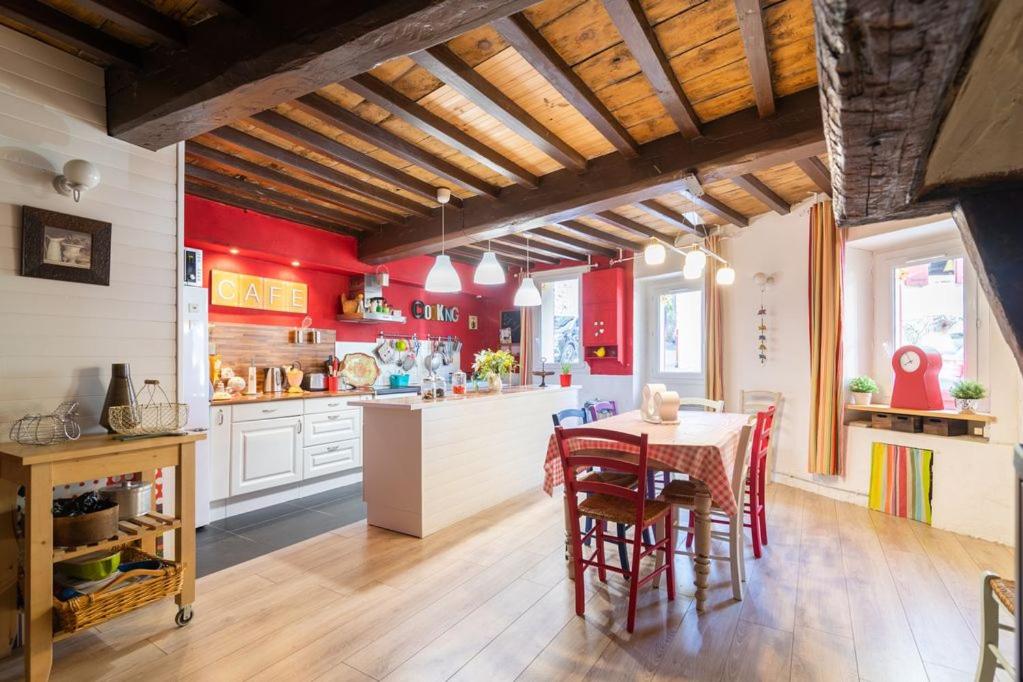 a kitchen with red walls and a table and chairs at La maison du Bonheur in Marquixanes
