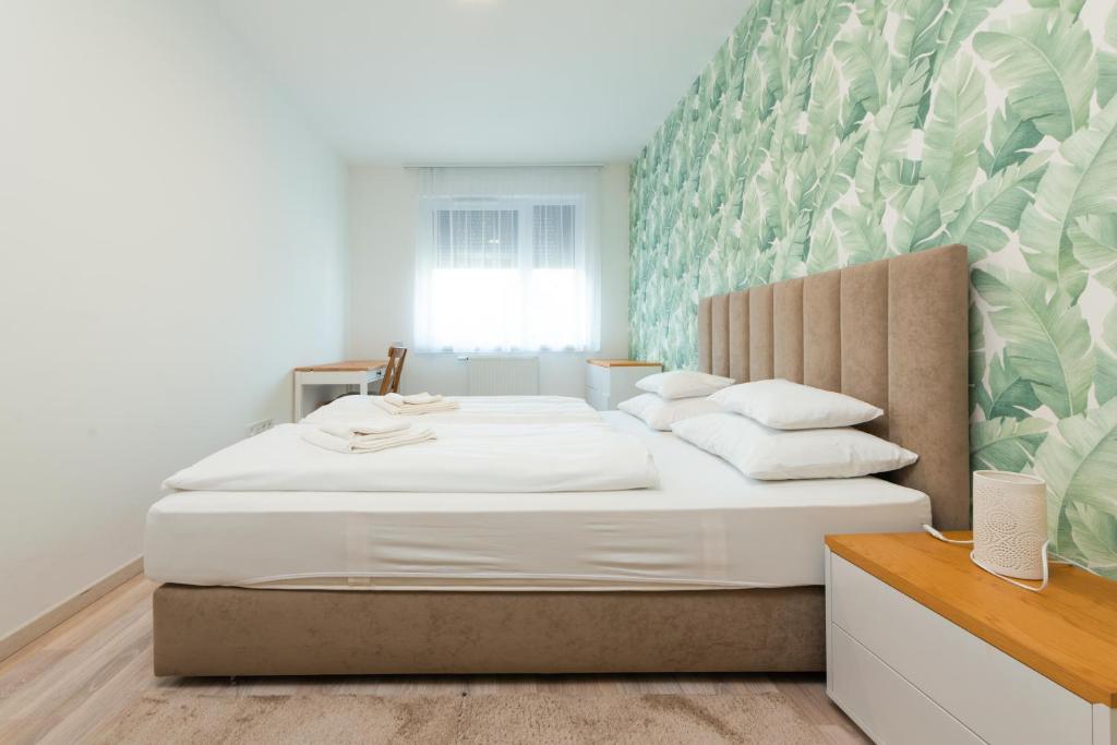 a bedroom with a large bed with white sheets and pillows at Dagály Apartments by UrbanRent in Budapest