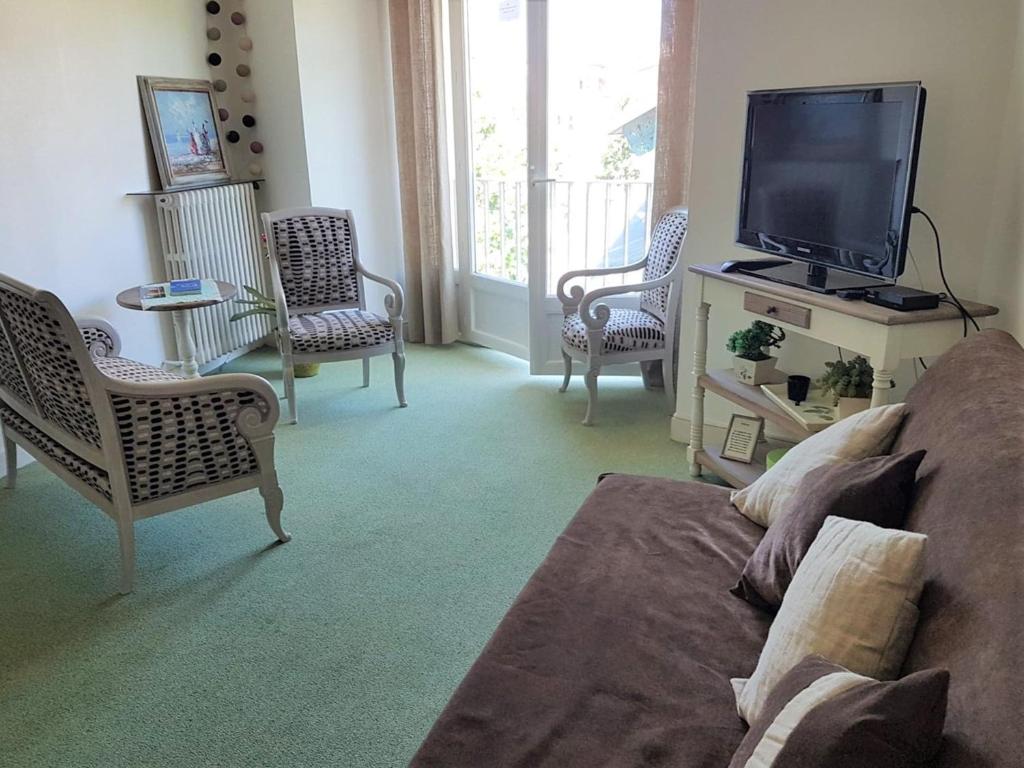 een woonkamer met een bank en een flatscreen-tv bij Appartement Saint-Jean-de-Luz, 2 pièces, 4 personnes - FR-1-4-545 in Saint-Jean-de-Luz