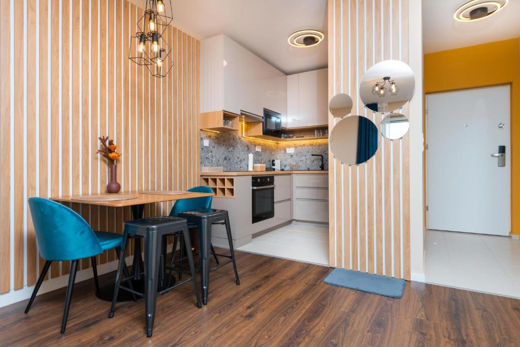 cocina con mesa de madera y sillas azules en WaterFront City Apartments by UrbanRent en Budapest