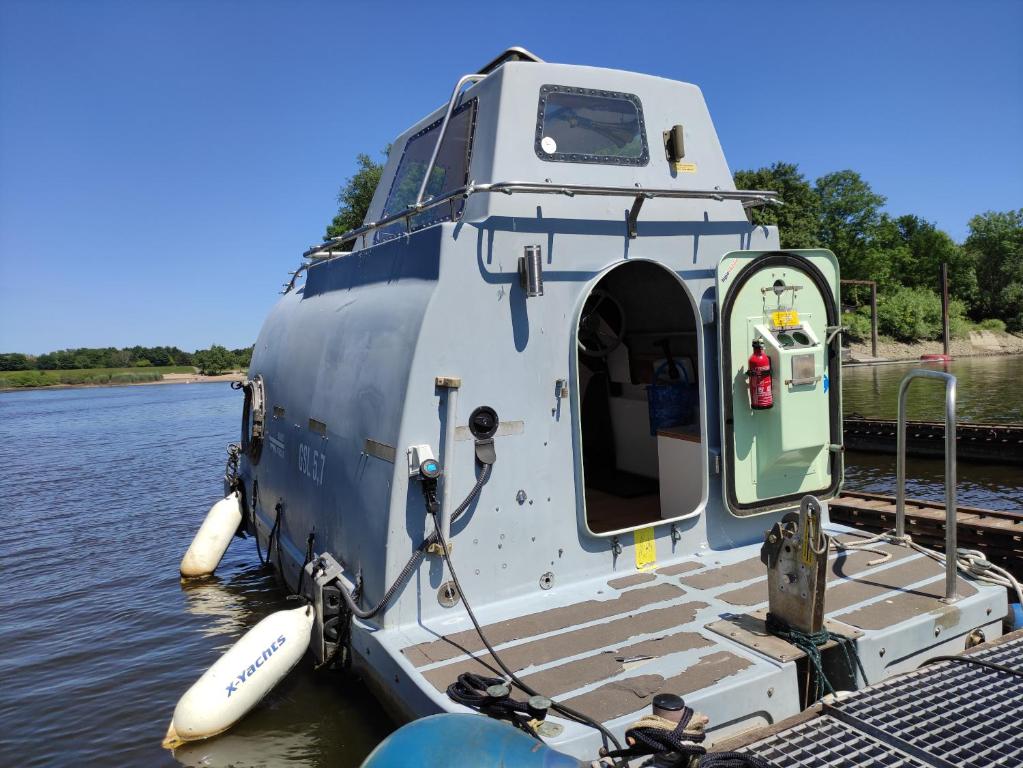 a small boat is docked on the water at Ausgebautes Rettungsboot GORCH POTT in Hamburg