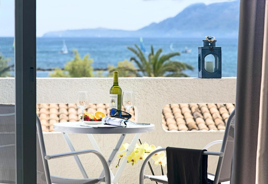a table with a bottle of wine and glasses on a balcony at Cabot Sivella Apartments in Port de Pollensa