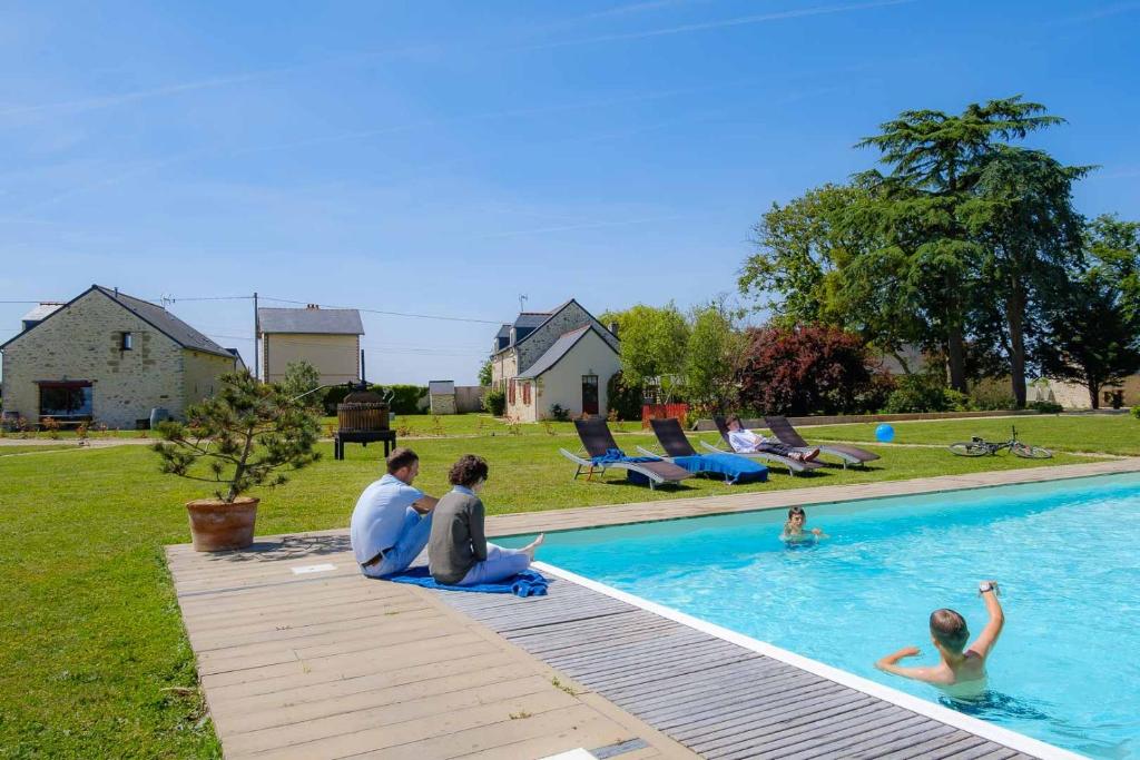 un gruppo di persone sedute in piscina di Le Domaine des Gauliers a Chavagnes