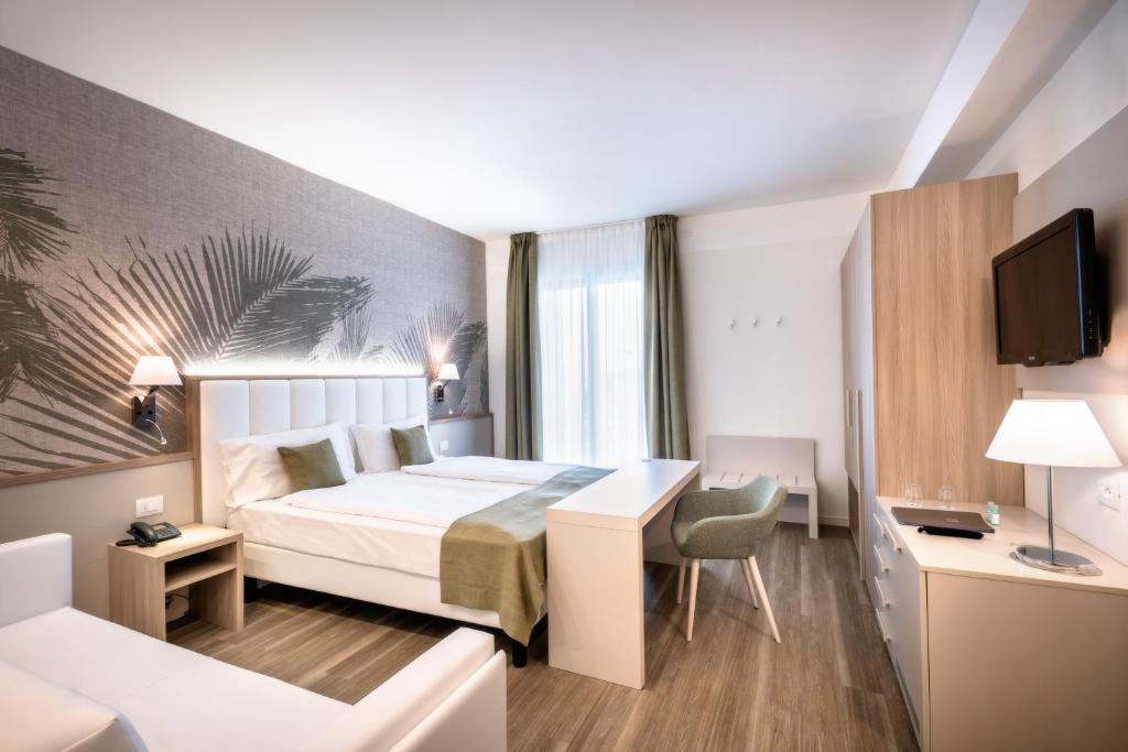 a hotel room with a bed and a desk at International Beach Hotel in Caorle
