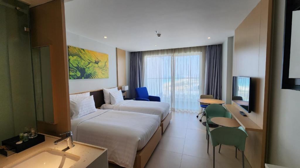 カムランにあるHome Seview at Cam ranh Nha Trang Aparmentのベッド2台とテレビが備わるホテルルームです。