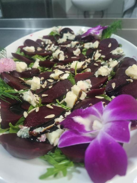 a plate of food with a purple flower on it at Ośrodek Wczasowy Bursztyn in Gdańsk