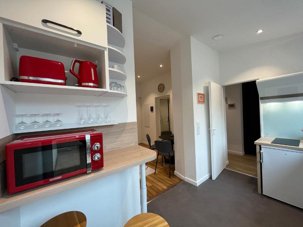 a kitchen with a red microwave on a counter at Suite Clovis 2 in Reims