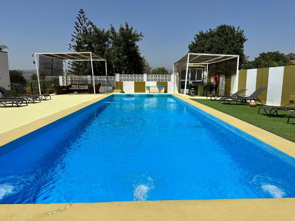 a large swimming pool with blue water at Casa Rural Emilio con 4 dormitorios in Málaga