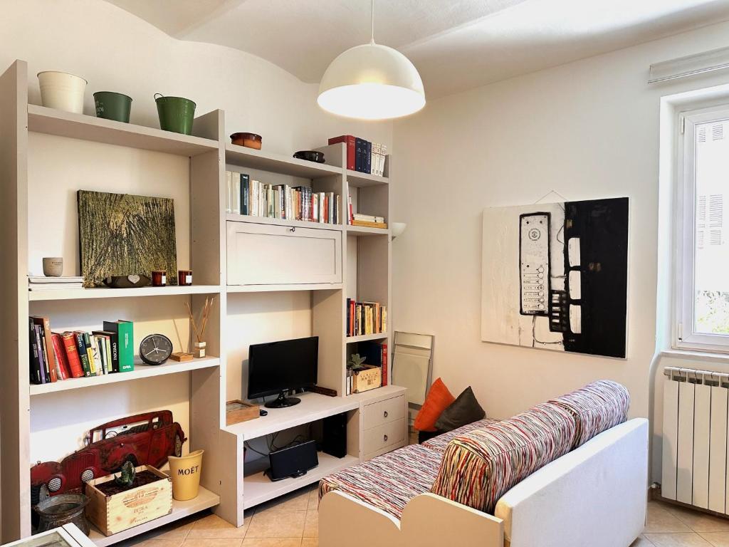 uma sala de estar com um sofá e prateleiras de livros em Centralissimo - Nuovo - Parcheggio Privato em Perugia