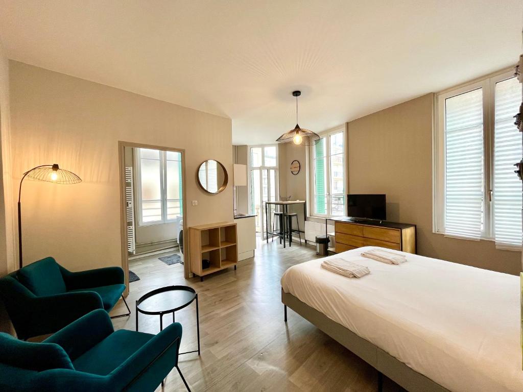 une chambre avec un grand lit et deux chaises dans l'établissement Suite Orphelins 3 1er, à Reims