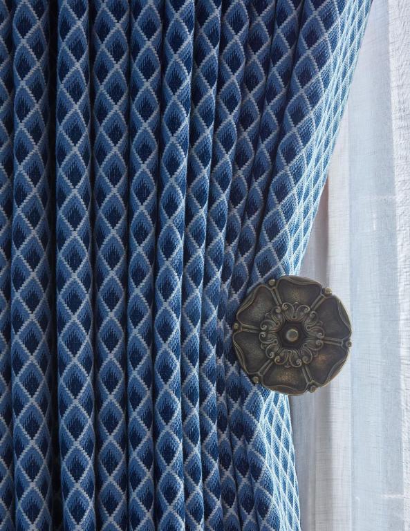 a close up of a blue curtain with a button at Broadwick Soho in London