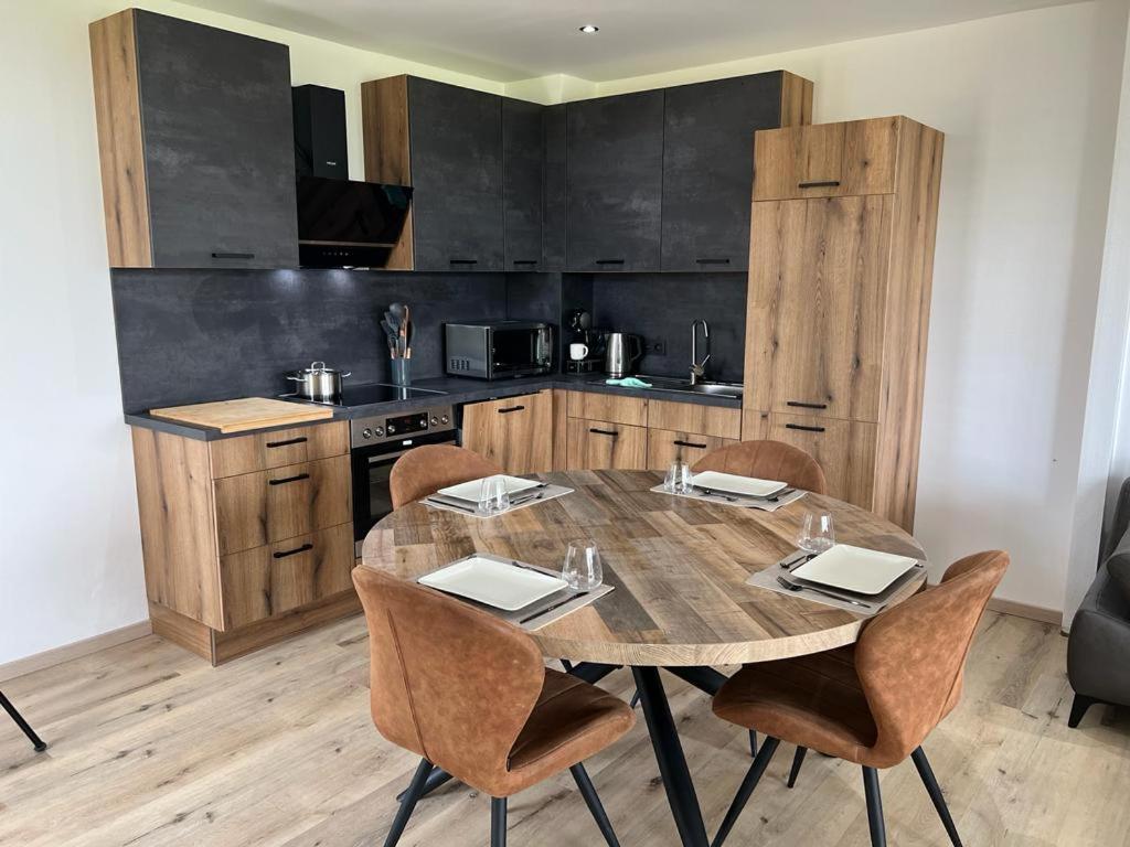 a kitchen with a wooden table and chairs in a room at Trees Fontain in Jalhay