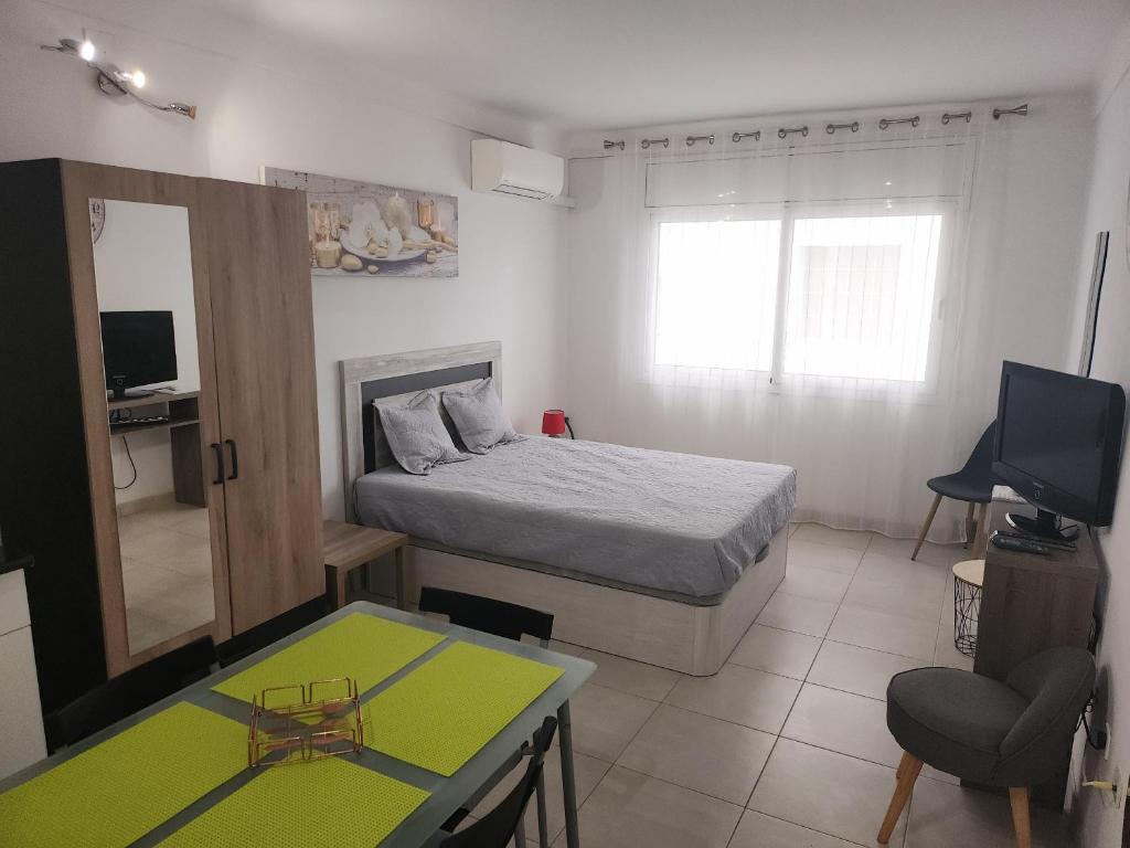 Dormitorio con cama, escritorio y TV en Pi y Sunyer 8 4 - Estudio a 50 m de la playa, en Roses