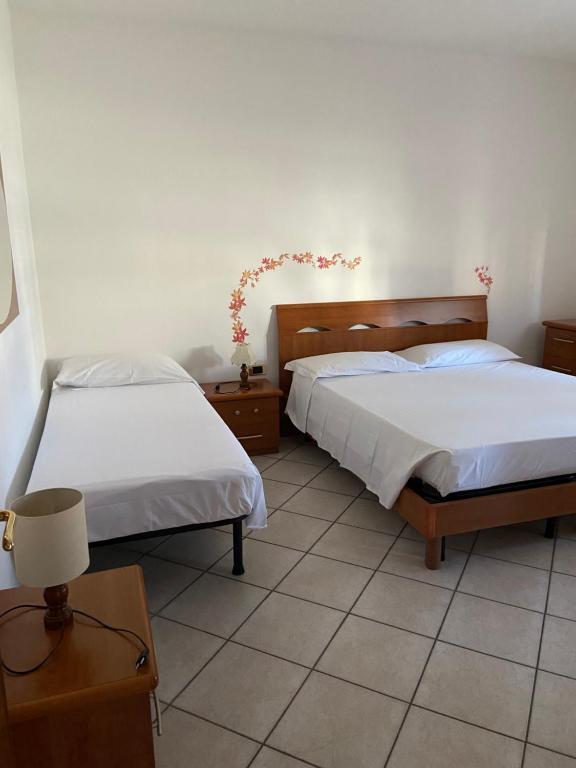 een slaapkamer met 2 bedden en een tafel met een lamp bij Balo’s home in Venturina Terme