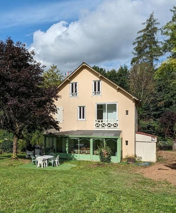 une grande maison avec une table de pique-nique dans la cour dans l'établissement Maison des années 30 - Vic-Sur-Cère - 14 personnes, à Vic-sur-Cère