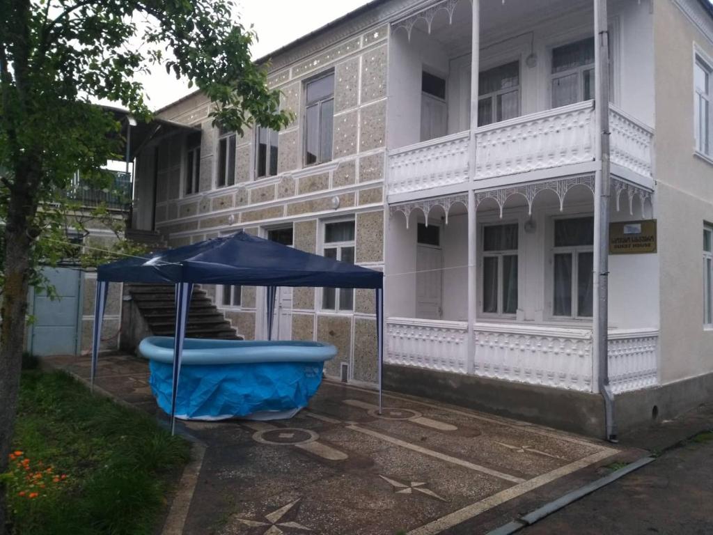 um guarda-chuva azul sentado em frente a um edifício em individual low-budget guest-house em Tsqaltubo